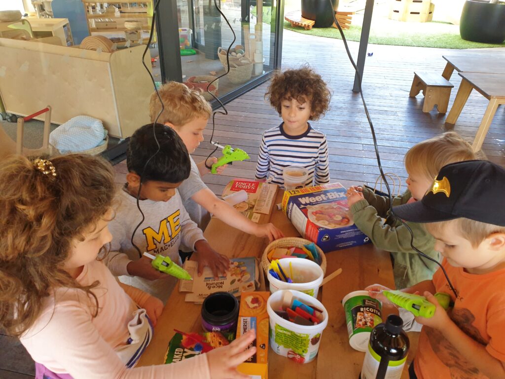 preschool children with cool melt glue guns making art and craft