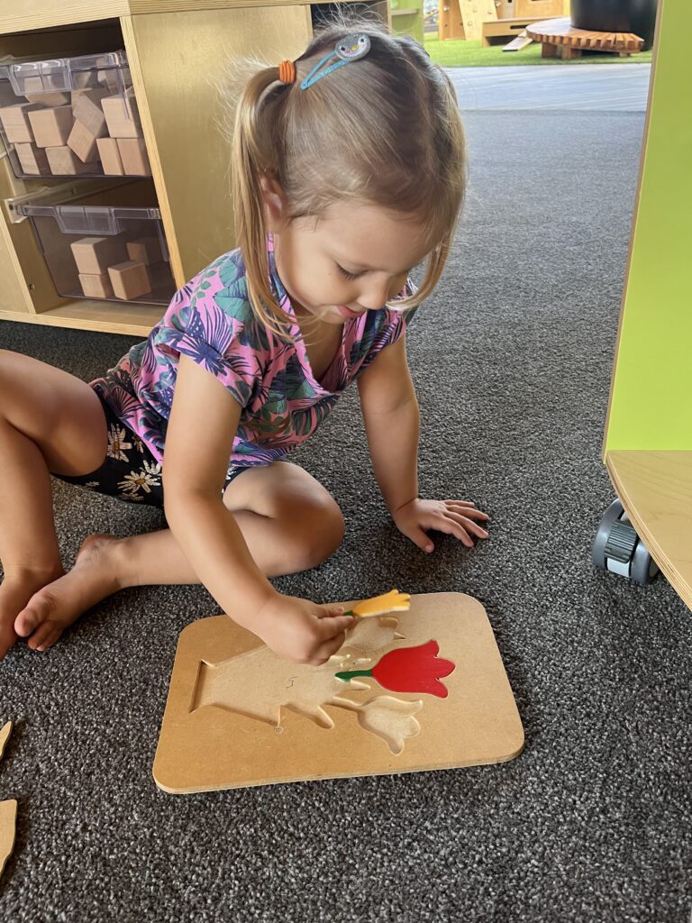 preschool child completing a flower jigsaw puzzle